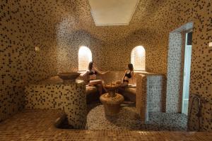 庫爾迪加的住宿－Mini hotel，两名妇女坐在带瓷砖墙壁的房间