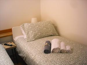 un letto con asciugamani e scarpe e un cuscino di Fikus APT relax Castello Ursino a Catania
