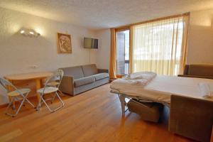 een kamer met een bed, een bank en een tafel bij Spinale del Sogno in Madonna di Campiglio