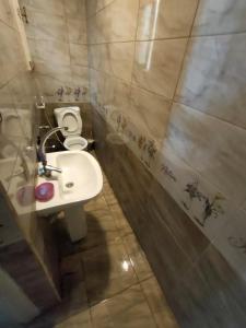 uma casa de banho com um lavatório branco e um WC. em Haidar House a private rooms for men only at shared apartment غرف خاصه للرجال فقط em Alexandria