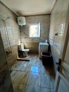 a bathroom with a toilet and a sink and a window at Haidar House a private rooms for men only at shared apartment غرف خاصه للرجال فقط in Alexandria