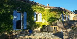 une maison avec du lierre sur son côté dans l'établissement Gites-Terroirs-Occitanie, à Felluns