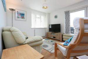 ein Wohnzimmer mit einem Sofa und einem TV in der Unterkunft BOURNECOAST: FLAT with PANORAMIC SEA VIEWS- FM6180 in Bournemouth