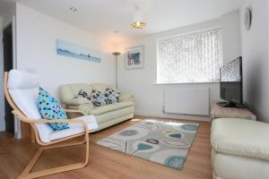 ein Wohnzimmer mit einem Sofa und einem Stuhl in der Unterkunft BOURNECOAST: FLAT with PANORAMIC SEA VIEWS- FM6180 in Bournemouth