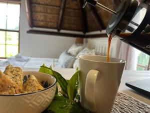 Eine Tasse Kaffee und eine Schüssel mit Essen auf einem Tisch in der Unterkunft Prospect Farm Cottages in George