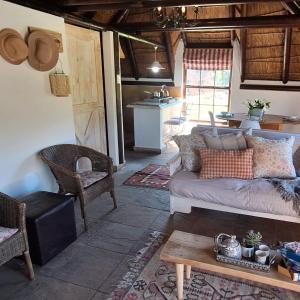 ein Wohnzimmer mit Sofa und Tisch in der Unterkunft Prospect Farm Cottages in George