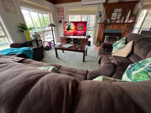 a living room with two couches and a tv at Nest On A Crest in Rye