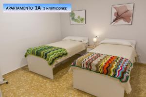 two beds in a room with two bedsskirts at Landete Holidays by Zagal Apartments in Valencia