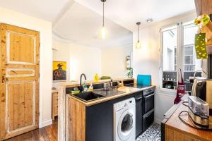 een keuken met een wasmachine en droger. bij GuestReady - Wonderful stay near Père-Lachaise in Parijs