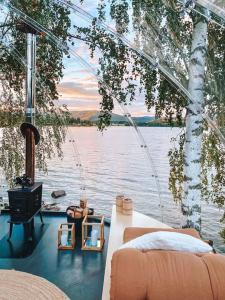 a boat with a bed and a stove on the water at Specatular glass-igloo by the water! 
