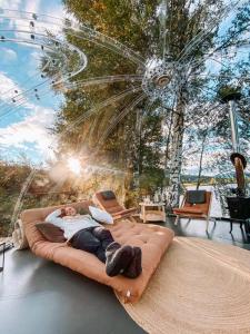 a woman laying on a bed in a glass house at Specatular glass-igloo by the water! 