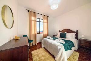 una camera da letto con un letto con un comò e uno specchio di Lombo Cesteiro Guesthouse a Tábua