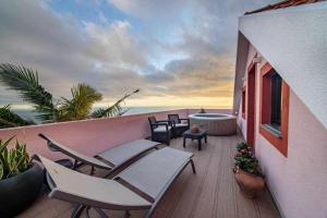 a balcony with chairs and a tub and the ocean at Lombo Cesteiro Guesthouse in Tábua