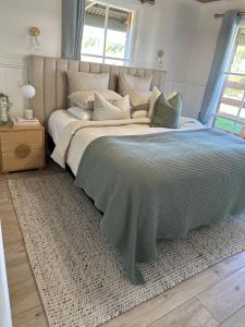een slaapkamer met een groot bed met een deken erop bij Serenity by the Sea Cottage in Apollo Bay with Jacuzzi in Marengo