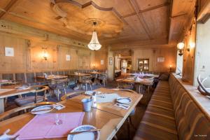 una sala da pranzo con tavoli e sedie in legno di B&B Villa Stelvio a Santa Maria Val Müstair