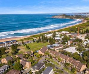 an aerial view of a beach with houses and the ocean at Reef Resort Apartments in Mona Vale