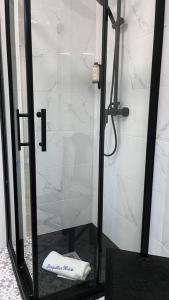 um chuveiro com uma porta de vidro e uma toalha branca em Perquilhas House 