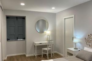 a bedroom with a bed and a desk with a mirror at Perquilhas House 