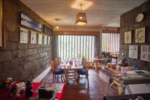 uma sala de jantar com uma mesa longa e cadeiras em Villa Rock Stop Falls em Nairobi