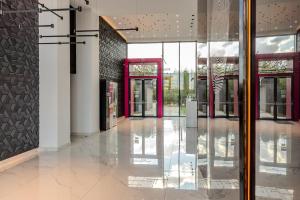un vestíbulo vacío con puertas de cristal en un edificio en Infinite Horizons - Modern Living in North Business District, en Bucarest