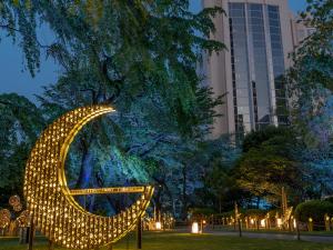 a sculpture of a crescent moon in a park at night at The Prince Sakura Tower Tokyo, Autograph Collection in Tokyo