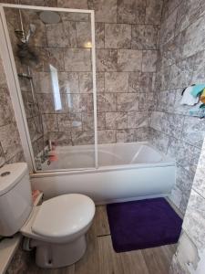 a bathroom with a white tub and a toilet at Brewery rd Double room in Plumstead