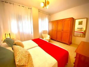 - une chambre avec un lit rouge et blanc et une armoire dans l'établissement MyChoice ElCano by Bossh! Apartments, à Rota