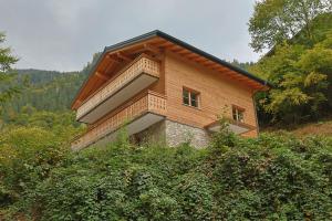 a building on top of a hill with trees at Haus Bödmenstein in Tschagguns