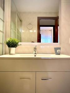 La salle de bains est pourvue d'un lavabo et d'un miroir. dans l'établissement MyChoice ElCano by Bossh! Apartments, à Rota