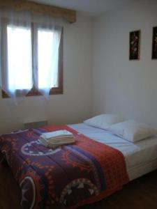 una camera da letto con un letto e asciugamani di Orelle 3 Vallées - 2 pièces 5/6 personnes a Orelle