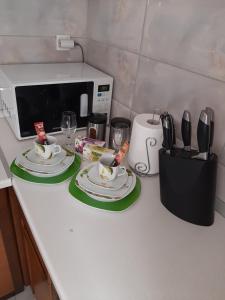 a kitchen counter with two plates and a microwave at Apartman-Glavas in Smederevska Palanka