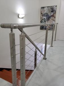 Una barandilla de metal en una habitación con una escalera en Tropical Rose Getaway en Discovery Bay