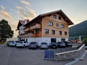 a large building with cars parked in a parking lot at Bergzeit - Hotel & Appartements in Oberjoch