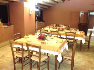 a dining room with tables and chairs with flowers on them at B&B Baglio Maragani in Maragani