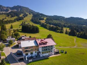 an aerial view of a house in a green field at Bergzeit - Hotel & Appartements in Oberjoch
