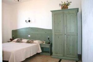 a bedroom with a bed and a dresser and a cabinet at B&B Baglio Maragani in Maragani
