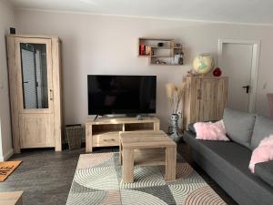 un soggiorno con divano e TV di Ferienwohnung (T)raumland a Bad Berleburg