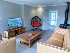 a living room with a couch and a tv at Prebbleton lifestyle Villa in Prebbleton