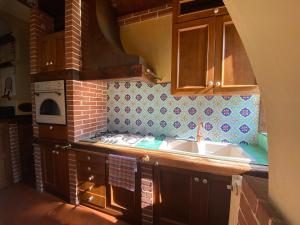 a kitchen with a sink and a stove at Casa Chiara, roof terrace, 100m to the historical center in Lecce