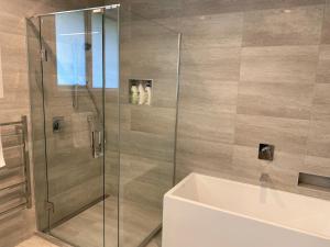 a shower with a glass door and a tub at Prebbleton lifestyle Villa in Prebbleton
