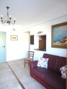 a living room with a couch and a painting on the wall at B&B Baglio Maragani in Maragani
