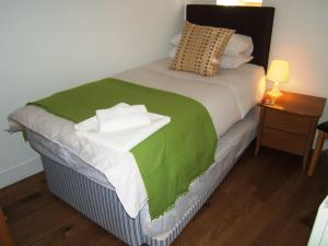 uma cama com um cobertor verde e branco em BOURNECOAST: CLOSE TO SHOPS / SANDY BEACH -FM4034 em Bournemouth