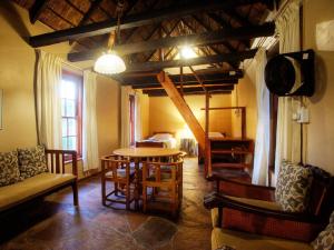 - un salon avec une table et des chaises dans l'établissement Zandvlakte Guest Farm, à Studtis