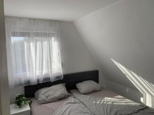 um pequeno quarto com uma cama e uma janela em Majos Lodge em Majosháza