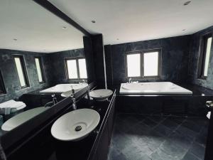 a large bathroom with two sinks and a tub and a bath tub at villa vue mer in Amphoe Koksamui