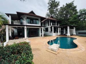 a house with a swimming pool in front of it at villa vue mer in Amphoe Koksamui