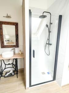 a shower with a glass door in a bathroom at Charmant studio paisible in Alençon