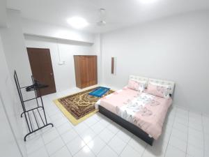 a bedroom with a bed with pink sheets and pillows at Uchi's Sunway Homestay in Petaling Jaya