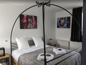 - une chambre avec un lit avec un cadre de lit en métal dans l'établissement Hotel et Spa Le Lion d'Or, à Pont-l'Évêque