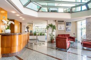 eine Lobby mit einer Bar und roten Stühlen in der Unterkunft Hotel Colorado Cesenatico in Cesenatico + 114 Fotos